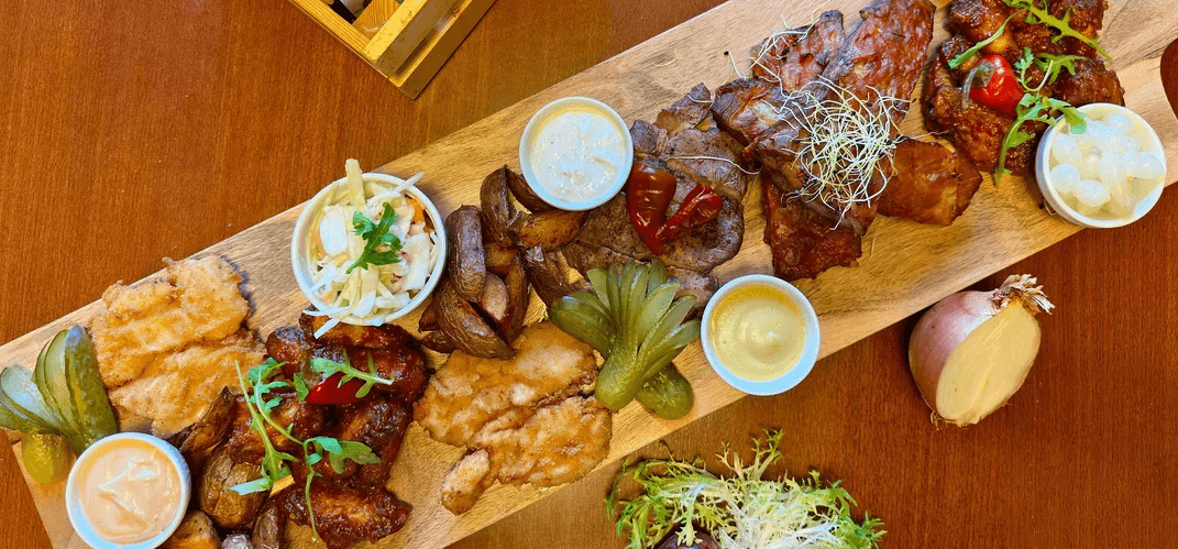 Masové prkno pro 2–4 osoby: vepřová žebírka, kuřecí křídla, steak z krkovice i americké brambory 