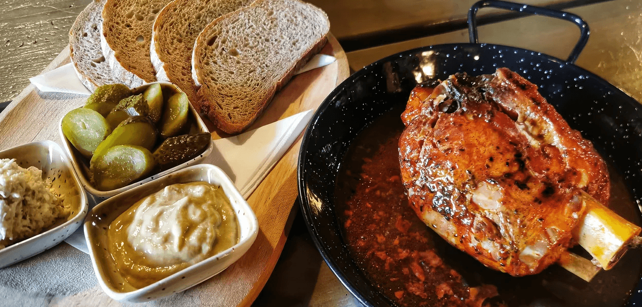 Pořádná hostina: pečené koleno o váze 750 g, chleba a omáčky
