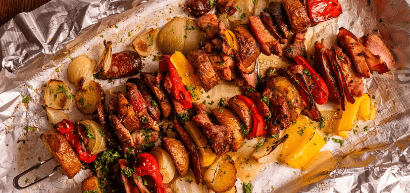 Živáňská pečeně - obří špíz (pečené vepřové maso s pikantní klobáskou, cibulí a bramborem podávané na prkně)