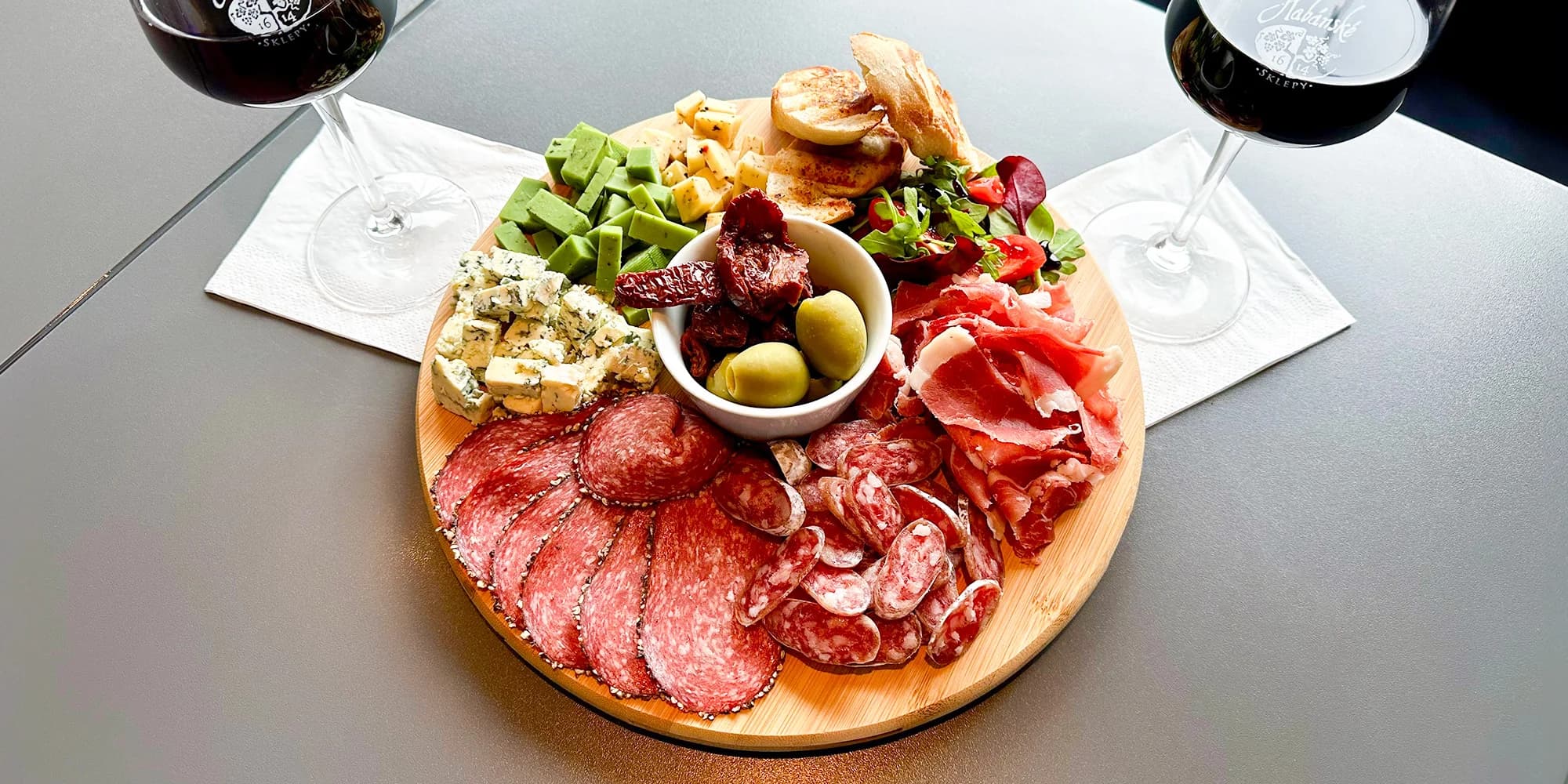 Degustační prkno pro 2-4 osoby: sýry, uzeniny, salátek, česneková bageta a červené víno k tomu