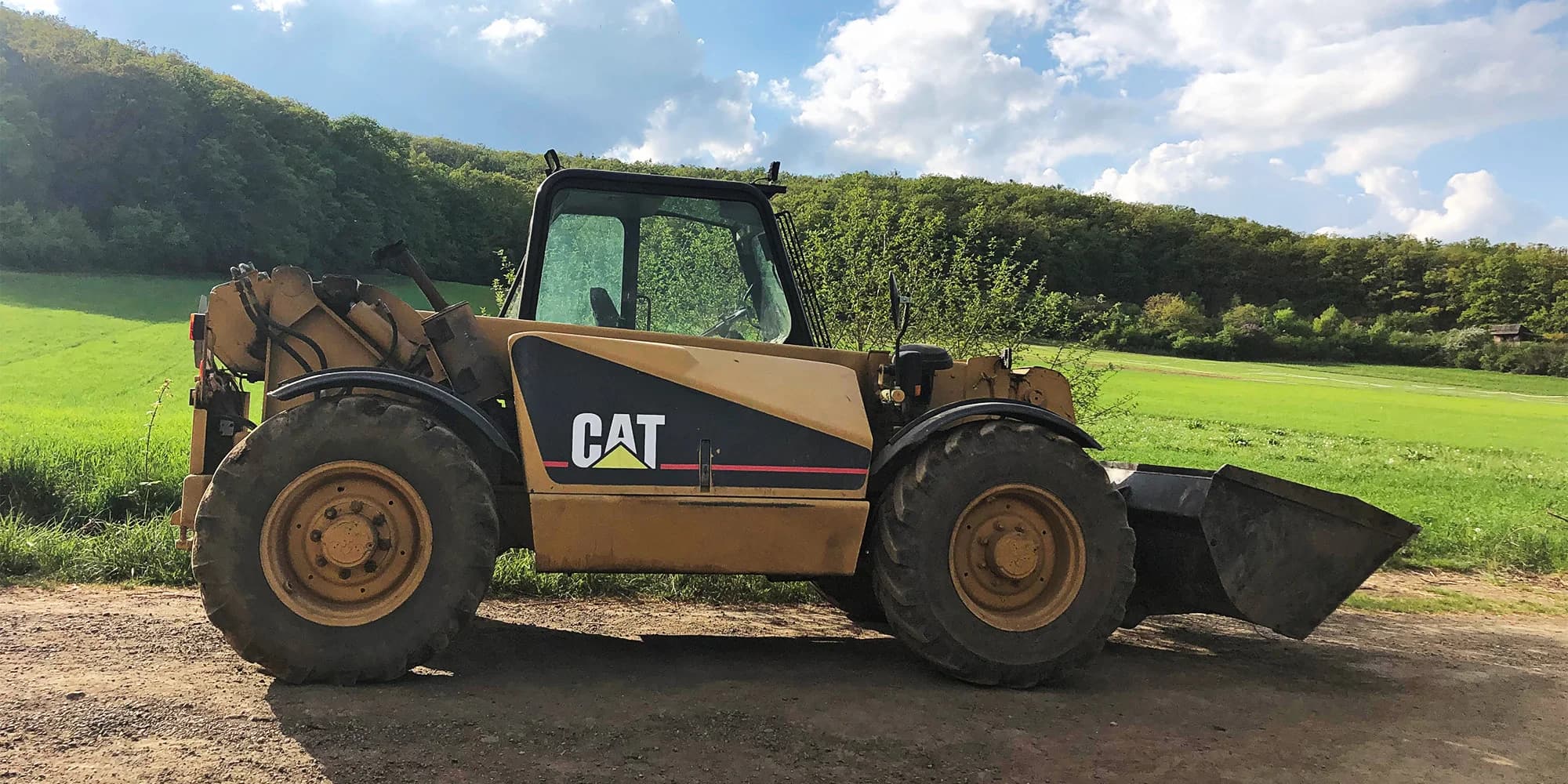 Farmářská jízda zručnosti v manipulátoru CAT: řízení, přerovnání zeminy i stěhování balíků sena a palet