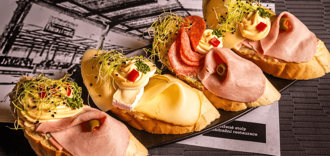 Prkno se 4 druhy domácích chlebíčků v oblíbené restauraci Olymp: 4–16 ks